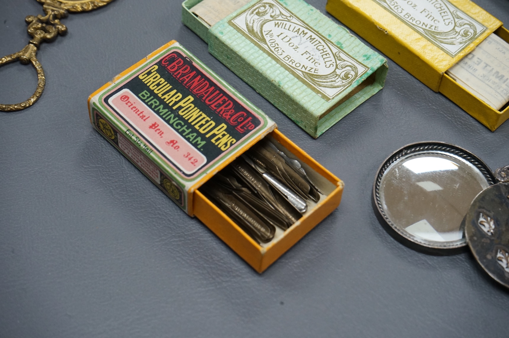 A small collection of objects to include a 17th century? French multi-cane glass seal, miniature white metal mirror and boxed pen nibs, seal 8cm high